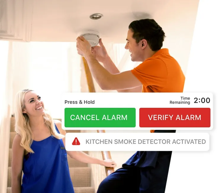 Technician installing a monitored smoke detector, with the alarm verification alert on screen